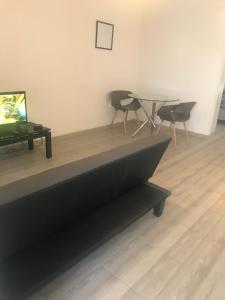sala de estar con mesa, sillas y TV en Modern secure apartment in Strand - Little Greece, en Strand