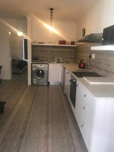 a large kitchen with a washer and dryer in it at Modern secure apartment in Strand - Little Greece in Strand