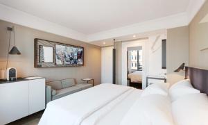 a bedroom with a white bed and a couch at Pestana Park Avenue in New York