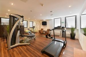 einen Fitnessraum mit Kardiogeräten im Wohnzimmer in der Unterkunft ACHAT Hotel München Süd in München