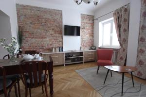 ein Wohnzimmer mit einem Tisch und einer Ziegelwand in der Unterkunft Krakowskie Przedmieście "Night and Day" in Warschau