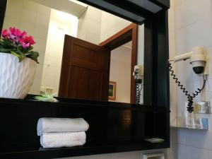 a bathroom with a mirror and a sink with towels at HOTEL PRINCIPE in Forlì