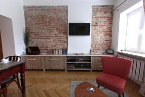 a living room with a red chair and a brick wall at Krakowskie Przedmieście "Night and Day" in Warsaw