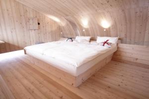 a bedroom with a large bed in a wooden room at Ufogel in Nußdorf