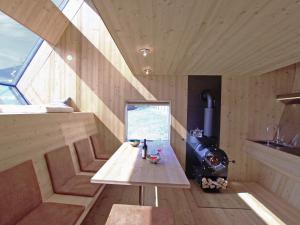 Ufogel في Nußdorf: غرفة صغيرة مع طاولة خشبية وموقد
