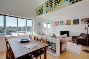 sala de estar con mesa y sofá en Beautiful duplex penthouse - roof garden, views, parking, en Newcastle