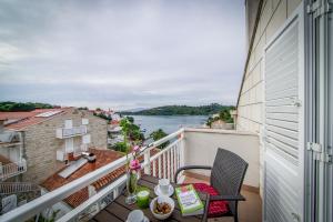 einen Balkon mit einem Tisch und Blick auf das Wasser in der Unterkunft Guest House Matana Pomena in Pomena