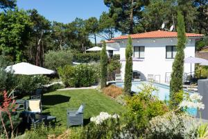 a garden with a swimming pool and a house at Ferret Vigne - Villa Chambres d'Hôtes in Cap-Ferret