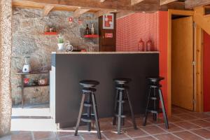 a kitchen with two bar stools at a counter at O Sequeiro in Vila Nova de Famalicão