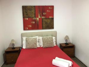 a bedroom with a red bed with two night stands at Lagos Downtown Guesthouse in Lagos