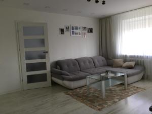 a living room with a couch and a glass table at Trakų street Apartment in Šiauliai