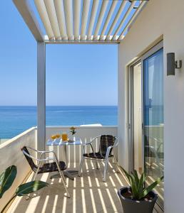 a balcony with a table and chairs and the ocean at Atrion Hotel in Heraklio
