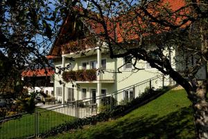 una casa blanca con una valla y un árbol en Weingut Zirngast en Leutschach