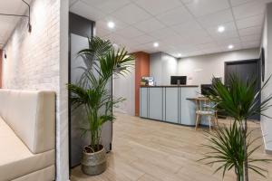 an office with two plants in an office lobby at Appart'City Confort Lille Grand Palais in Lille