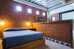 um quarto com uma cama e uma parede de tijolos em Terraza del Alférez em Xalapa