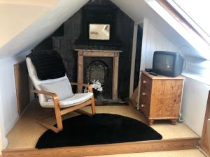 a living room with a chair and a tv at Lauras Townhouse Apartments Skylight Loft in Bath