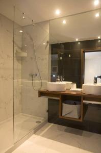 uma casa de banho com 2 lavatórios e uma cabina de duche em vidro. em Gare da Fonte Nova - Aveiro em Aveiro