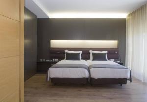 1 dormitorio con 2 camas y una luz en la pared en Gare da Fonte Nova - Aveiro en Aveiro