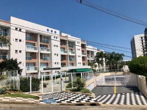 a large apartment building with a courtyard in front of it at Apartamento Familiar Guaruja in Guarujá