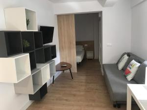 a living room with a couch and a bedroom at Pescadors Apartamentos TRG in Benidorm