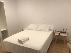 a white bed with two towels on top of it at Pescadors Apartamentos TRG in Benidorm