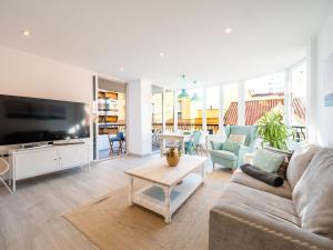 a living room with a couch and a tv at PREMIUM BEACH DESIGN - La Malagueta in Málaga