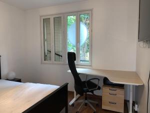 escritorio y silla en una habitación con ventana en Appartement 3 pièces, en Noisy-le-Sec