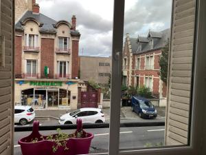 una ventana con vistas a una calle de la ciudad con coches en Appartement 3 pièces, en Noisy-le-Sec
