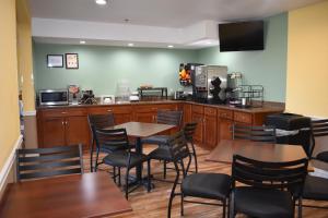 un restaurante con mesas y sillas de madera y una cocina en Americas Best Value Inn Manteca, en Manteca