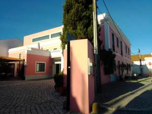 um grupo de edifícios numa rua de calçada em Hotel Acez em Vendas Novas