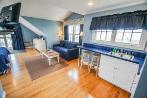 a kitchen and living room with blue walls and wooden floors at Beachside Village Resort, a VRI resort in Falmouth