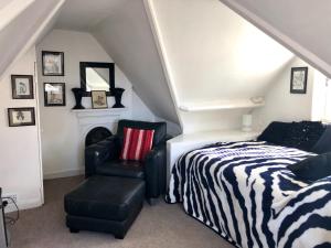 a bedroom with a bed and a chair at Lauras Townhouse Apartments Skylight Loft in Bath