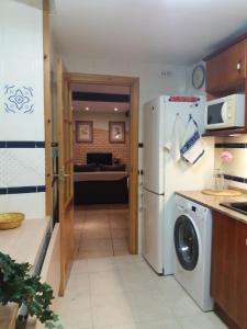 a kitchen with a refrigerator and a living room at Ventallols in Tarragona