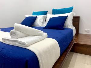 1 cama con sábanas azules y blancas y almohadas azules en SECRET ROOM NAPLES historic center, en Nápoles