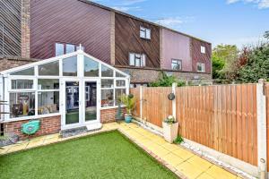 a garden with a conservatory in front of a house at Docklands Stay, Room in Modern Spacious House - Near Excel Centre, City Airport, UEL,Sleeps 2 in London