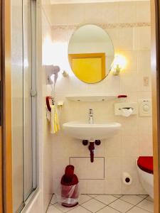 W łazience znajduje się umywalka i lustro. w obiekcie Hotel Kull von Schmidsfelden w mieście Bad Herrenalb