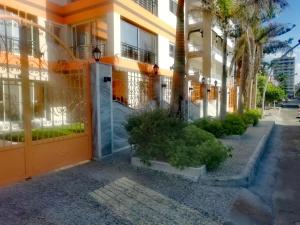 un edificio naranja con plantas delante de él en Al Raya Apartments en Alexandría