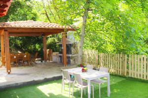 a white table and chairs in a backyard with a gazebo at Casa Vacanze Il Giardino - Appartamento Nocciolo in Aritzo