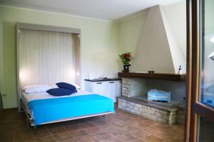 a bedroom with a blue bed and a fireplace at Casa Vacanze Il Giardino - Appartamento Nocciolo in Aritzo