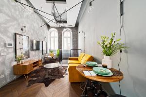 a living room with a yellow couch and a table at House of LoftAffair in Krakow