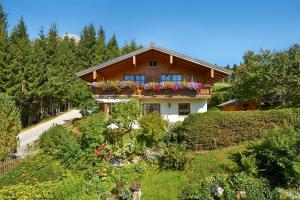 een huis op een heuvel met bloembakken erop bij Appartment Rettenwender in Filzmoos