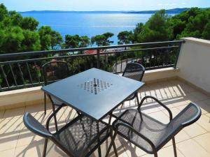 una mesa y sillas en un balcón con vistas al agua en Apartments Staničić, en Brela