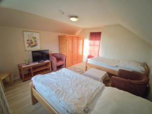 a hotel room with two beds and a television at Gästehaus Tiedemann in Borsfleth