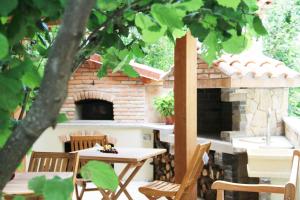 a patio with a table and chairs and a brick oven at Casa Vacanze Il Giardino - Appartamento Nocciolo in Aritzo +17 photos