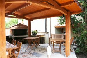 a wooden pavilion with a table and chairs and a fireplace at Casa Vacanze Il Giardino - Appartamento Nocciolo in Aritzo