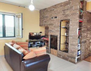 ein Wohnzimmer mit einem Sofa und einem Steinkamin in der Unterkunft Villetta tra gli agrumeti in Corigliano Calabro