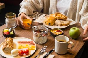 a person sitting at a table with breakfast foods at ibis Brussels Centre Chatelain in Brussels