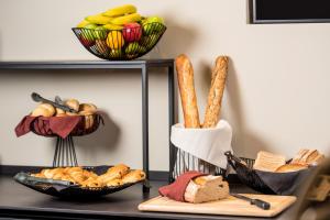 a shelf with baskets of bread and baskets of pastries at ibis Brussels Centre Chatelain in Brussels