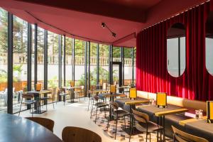 a restaurant with red walls and tables and chairs at ibis Brussels Centre Chatelain in Brussels +36 photos