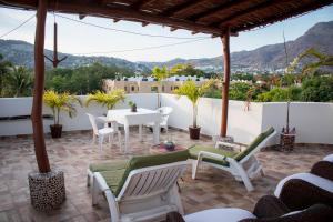 a patio with a table and chairs and a view at Canto del Mar Hotel - Zihuatanejo - Suites con Cocina in Zihuatanejo